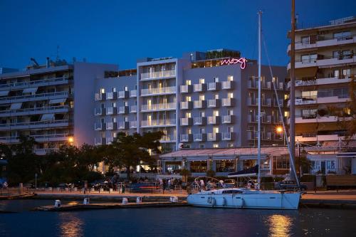 a boat in the water in front of a hotel at Moxy Patra Marina in Patra