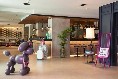 a restaurant with purple chairs and a bar at Moxy Patra Marina in Patra