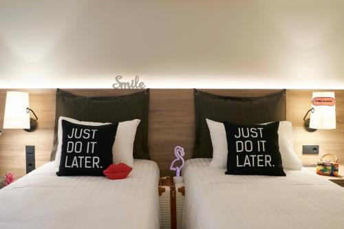 two beds sitting next to each other in a room at Moxy Patra Marina in Patra