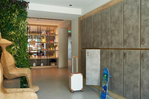a room with a suitcase and some lockers at Moxy Patra Marina in Patra