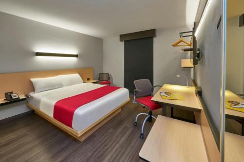 a hotel room with a bed and a desk and a desk at City Express by Marriott La Raza in Mexico City