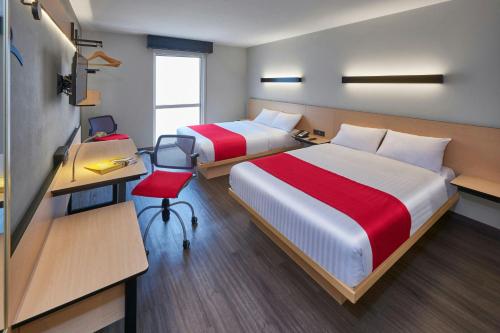 a hotel room with two beds and a desk and a desk at City Express by Marriott La Raza in Mexico City