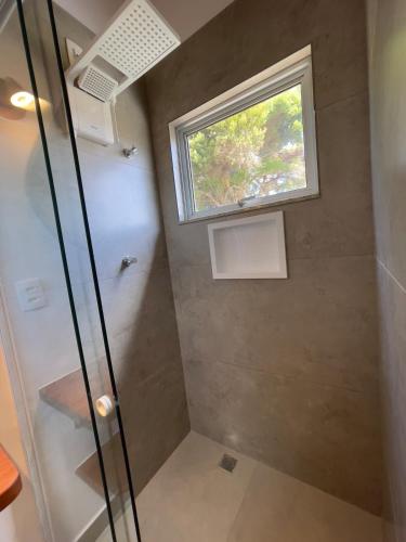 a bathroom with a shower with a window at Tiny Garden House in Santa Rita do Sapucaí