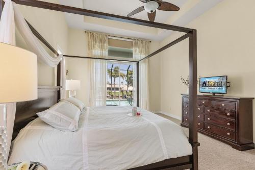 a bedroom with a canopy bed with a dresser and a window at Villa Azurro, Cape Coral in Cape Coral