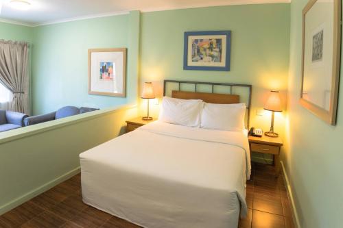 a bedroom with a large white bed and a chair at Protea Hotel by Marriott Dar es Salaam Oyster Bay in Dar es Salaam