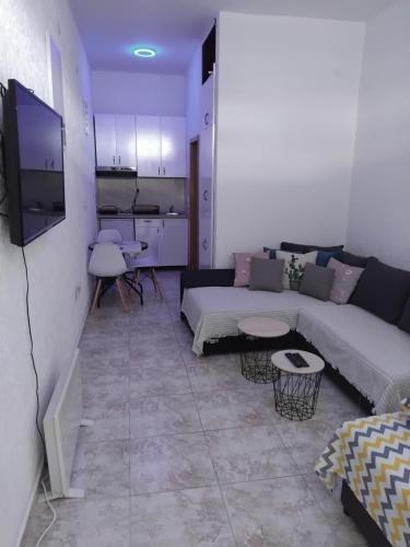 a living room with a couch and a tv at AK apartman in Sutomore