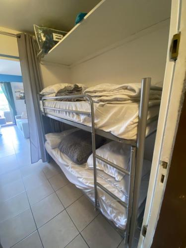 une chambre avec trois lits superposés dans une pièce dans l'établissement Le Paradis Bleu, à Cavalaire-sur-Mer