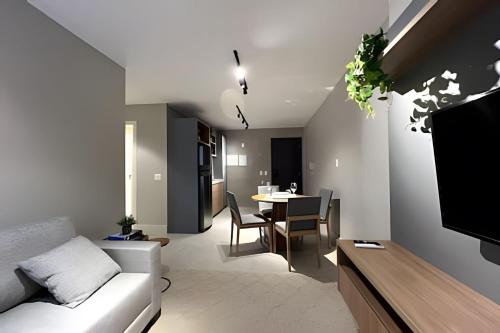 a living room with a couch and a dining room at Noroeste, Apt. moderno e central in Brasilia