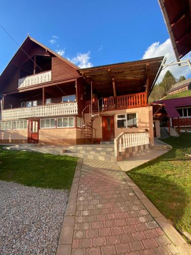 a large building with a staircase in front of it at Pensiunea Daiana in Albac