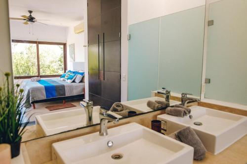 a bathroom with two sinks and a large mirror at Serene Jungle Villa -Steps from the Ocean in Akumal