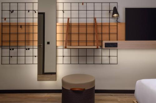 a room with a stool and tiled wall at Moxy Lisboa Oriente in Lisbon