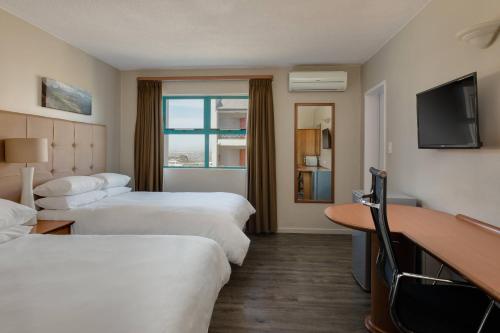 a hotel room with two beds and a television at Protea Hotel by Marriott Cape Town Tyger Valley in Bellville