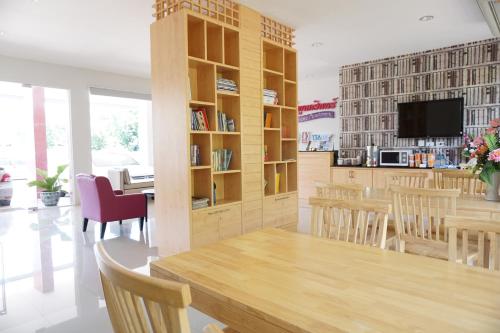 a dining room with a table and chairs and a tv at Chompu Nakarin Apartment in Trang