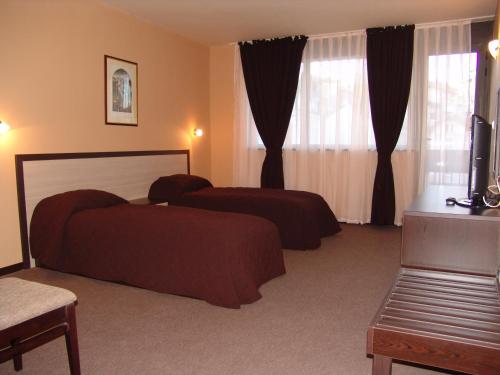 um quarto de hotel com duas camas e uma televisão em Hotel Lovech em Lovech