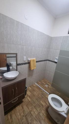 a bathroom with a toilet and a sink at Casa Barrio del Lago in Garupá