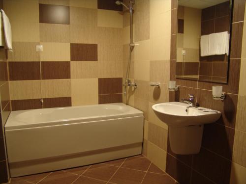 a bathroom with a sink and a tub and a toilet at Hotel Lovech in Lovech