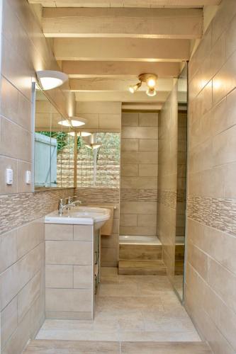 une salle de bain avec un lavabo et une douche dans l'établissement Gîte d'exception tout confort pour vacances - Piscine et loisirs incomparables - 6 chambres !, à Lamonzie-Saint-Martin