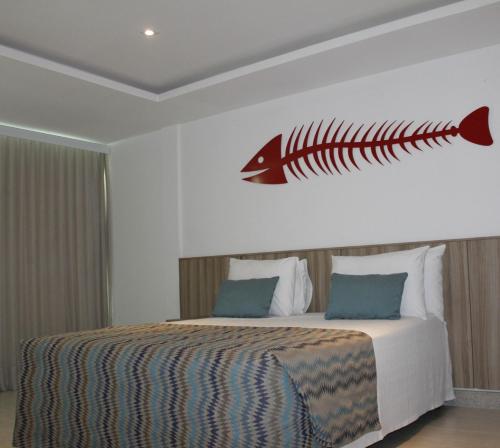 a bedroom with a bed with a fish on the wall at Paradiso Peró Praia Hotel in Cabo Frio