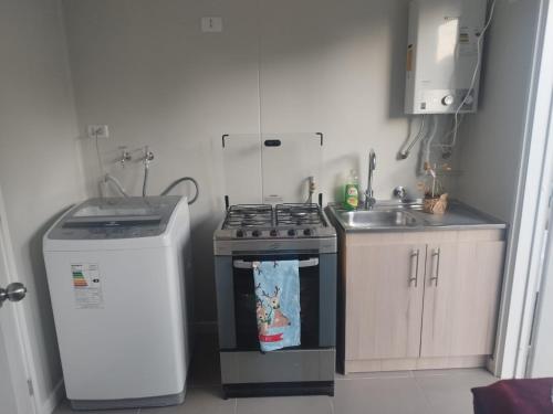 a small kitchen with a stove and a sink at Casa para 6 personas in Villarrica