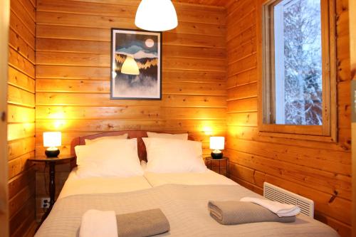 a bedroom with a bed in a wooden room at Villa Oitola I Parking I Sauna I Wifi I Lake I Rural I Forest I Ideal for Aurora spotting in Sonka