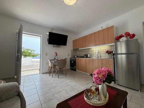 a kitchen with a stainless steel refrigerator and a table at Iliaxtida Seaside Apartment in Kalamaki Heraklion