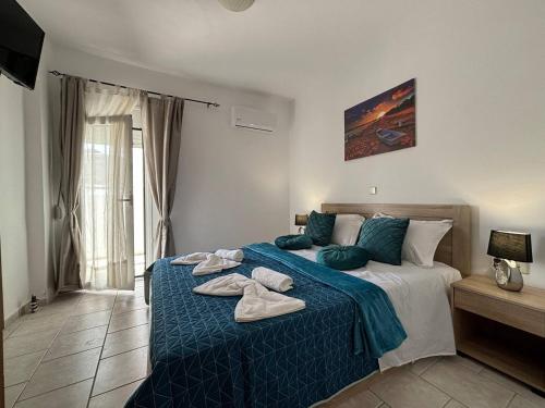a bedroom with a bed with towels on it at Iliaxtida Seaside Apartment in Kalamaki Heraklion
