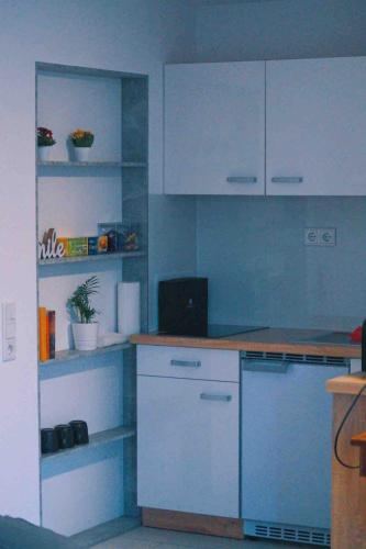 a kitchen with white cabinets and a counter top at Tulip apartment with your private entrance in Baunatal