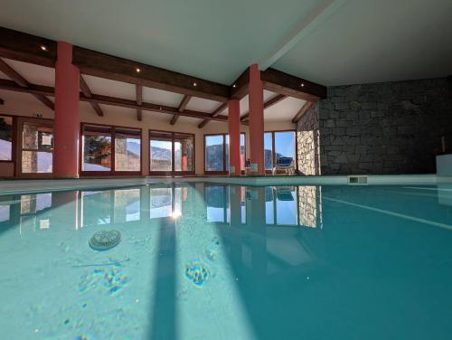 une piscine avec de l'eau bleue dans un immeuble dans l'établissement New Luxury Property at Vanoise Express Sauna, à Peisey-Nancroix