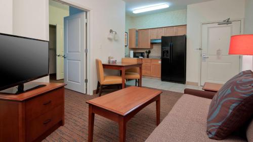 a living room with a couch and a table and a kitchen at Residence Inn by Marriott San Antonio North Stone Oak in San Antonio