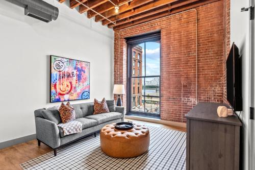 a living room with a couch and a table at Brick & Bed Riverfront Lofts, G 209 in Saint Louis