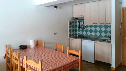 a small kitchen with a table and a table and chairs at Rododendro Apartment in Passo San Pellegrino