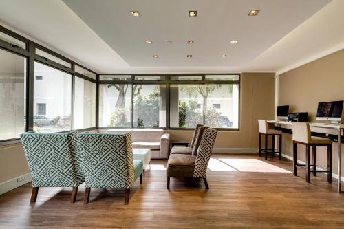 a living room with a table and chairs at Protea Hotel by Marriott Cape Town Waterfront Breakwater Lodge in Cape Town