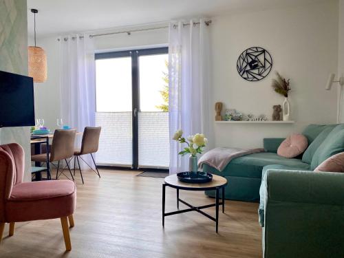 a living room with a green couch and a table at FeWo Zur Wasserburg in Oelsnitz/Vogtland