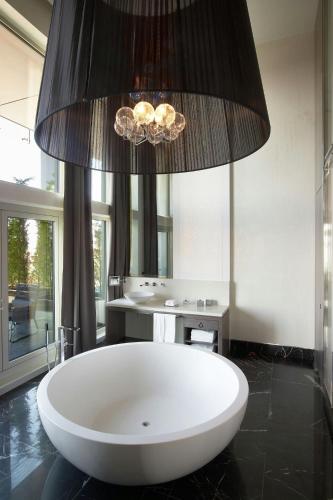 a large white tub in a bathroom with a mirror at Le Meridien Istanbul Etiler in Istanbul