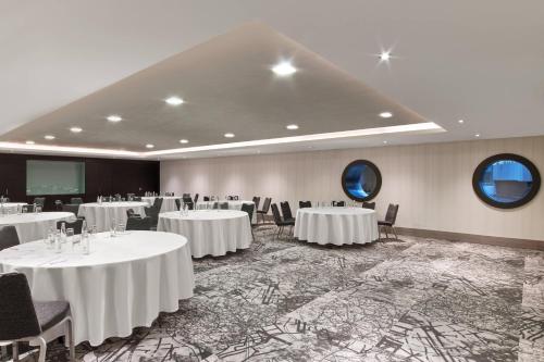 a conference room with white tables and chairs and a screen at Le Meridien Istanbul Etiler in Istanbul