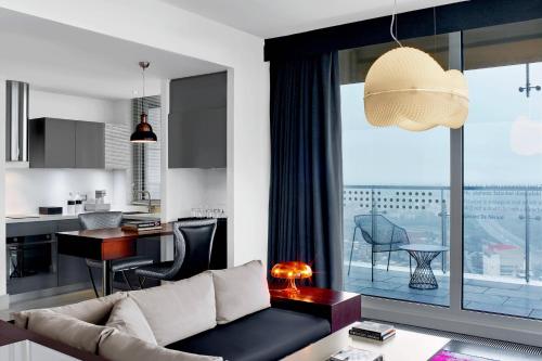 a living room with a couch and a kitchen at Le Meridien Istanbul Etiler in Istanbul