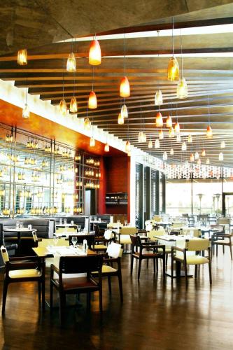 a dining room with tables and chairs and lights at Le Meridien Istanbul Etiler in Istanbul
