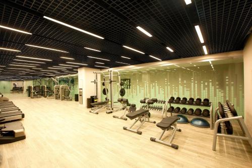 a gym with several treadmills and exercise equipment on the wall at Le Meridien Istanbul Etiler in Istanbul