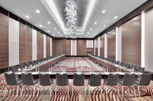an empty conference room with chairs and tables and a chandelier at Le Meridien Istanbul Etiler in Istanbul
