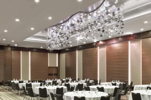 a banquet hall with white tables and chairs and a chandelier at Le Meridien Istanbul Etiler in Istanbul