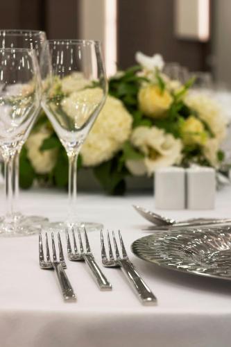 a table with silverware and glasses on a table at Le Meridien Istanbul Etiler in Istanbul