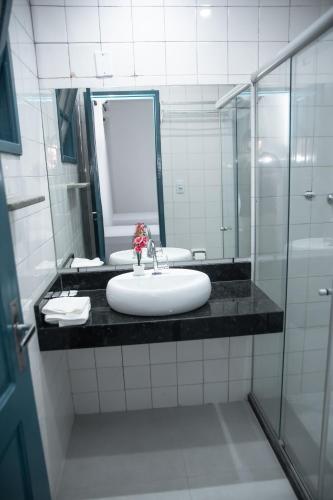 a bathroom with a sink and a mirror at Hotel Praia do Morro in Guarapari