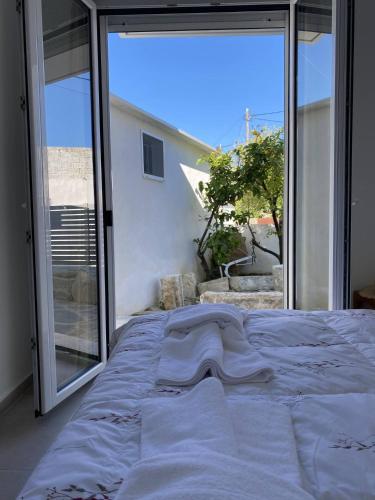 a bed in a bedroom with a large window at Orphanos Apartment in Kamilari