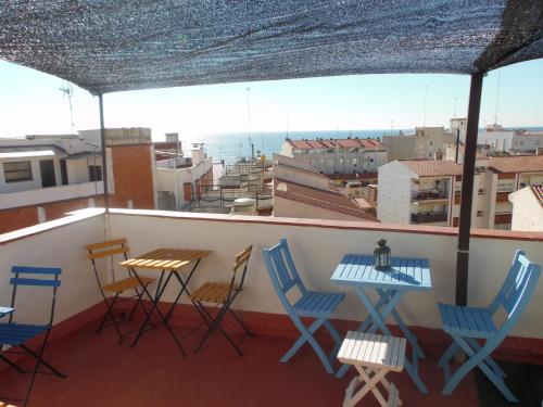 a balcony with chairs and tables and a view of the ocean at Hostal La Lluna in Arenys de Mar