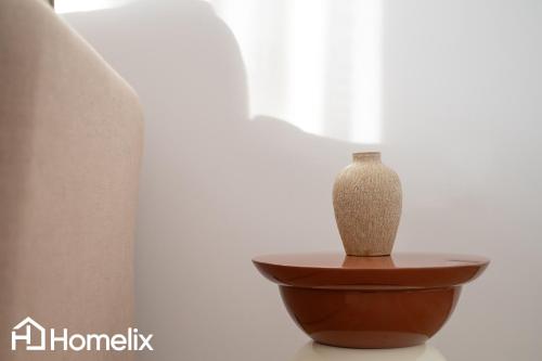 a vase sitting on a table next to a window at AMAYA - Sea View Suites in Chalkida
