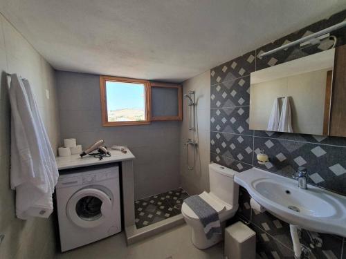 ein Badezimmer mit Waschmaschine und Waschbecken in der Unterkunft Poseidon House, With Seaview in Kalamaki