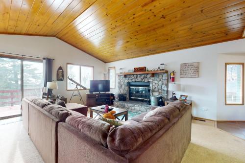 a living room with a large couch and a fireplace at Victoria Court Vacation in Lake Arrowhead