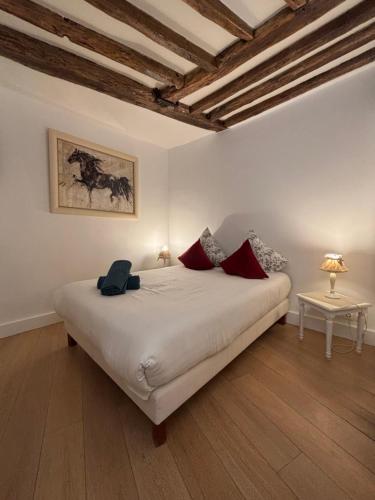 une chambre avec un grand lit blanc avec des oreillers rouges dans l'établissement Opera Royal House, à Paris