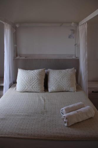 a bed with two towels sitting on top of it at Cozy Lounge - Visit Langebaan in Langebaan
