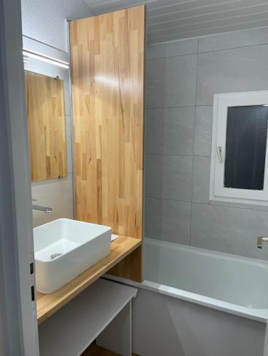 une salle de bain avec un lavabo blanc et un miroir dans l'établissement Maison avec jardin- à 3' du lac, à Hourtin